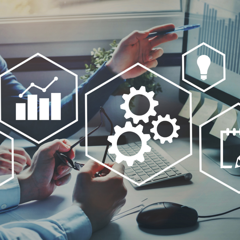 Professionals working at a computer with overlaid digital icons representing analytics, automation gears, business strategy, and scheduling.
